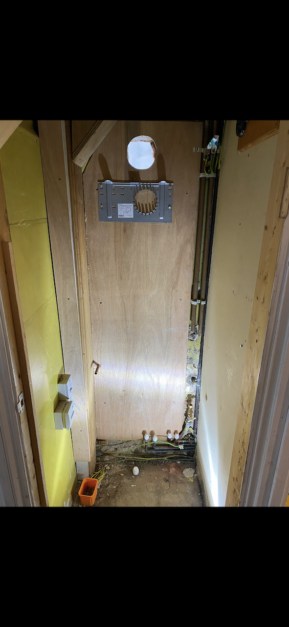 Cupboard stripped ready for new boiler with flue plate fitted