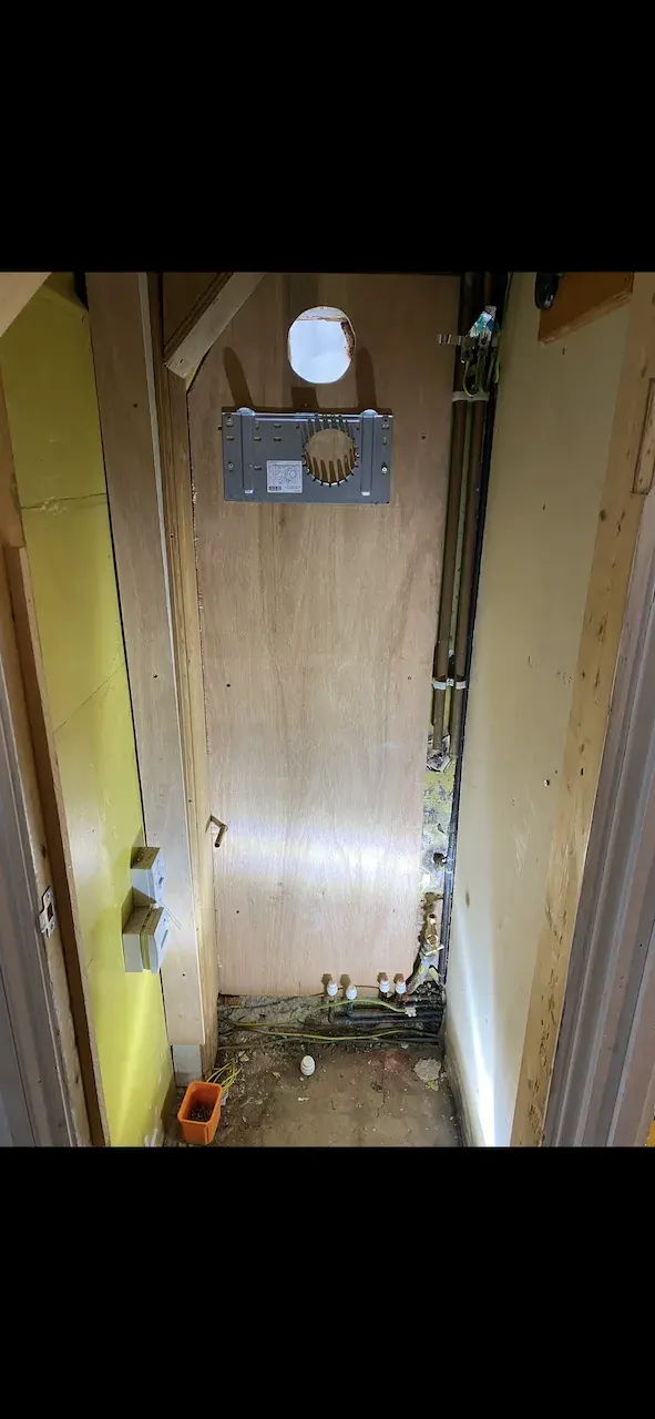 Cupboard stripped ready for new boiler with flue plate fitted