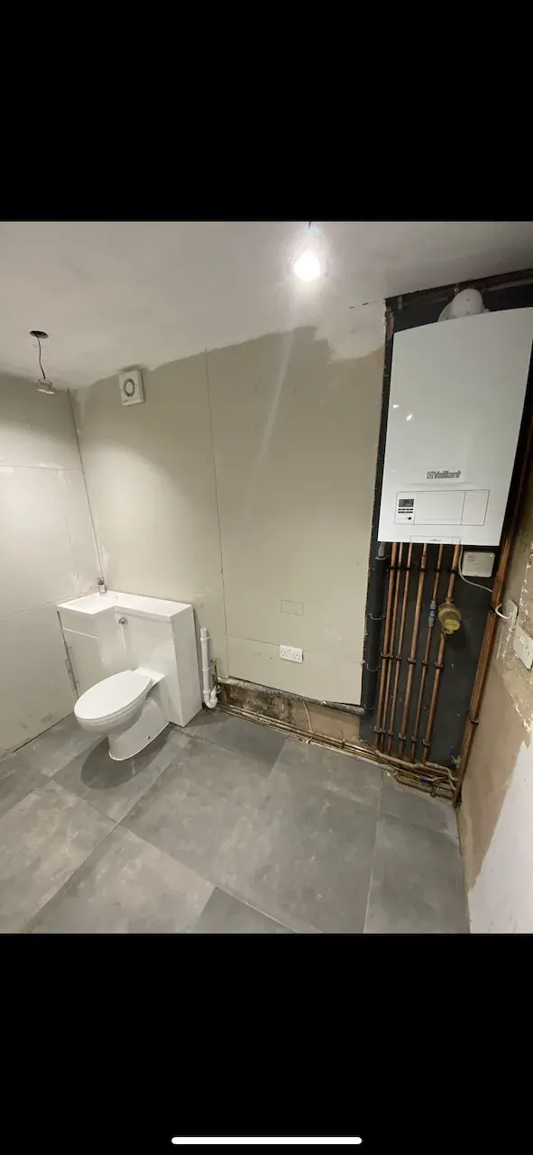 Finished room with Vaillant boiler, toilet and basin unit, tiled floor