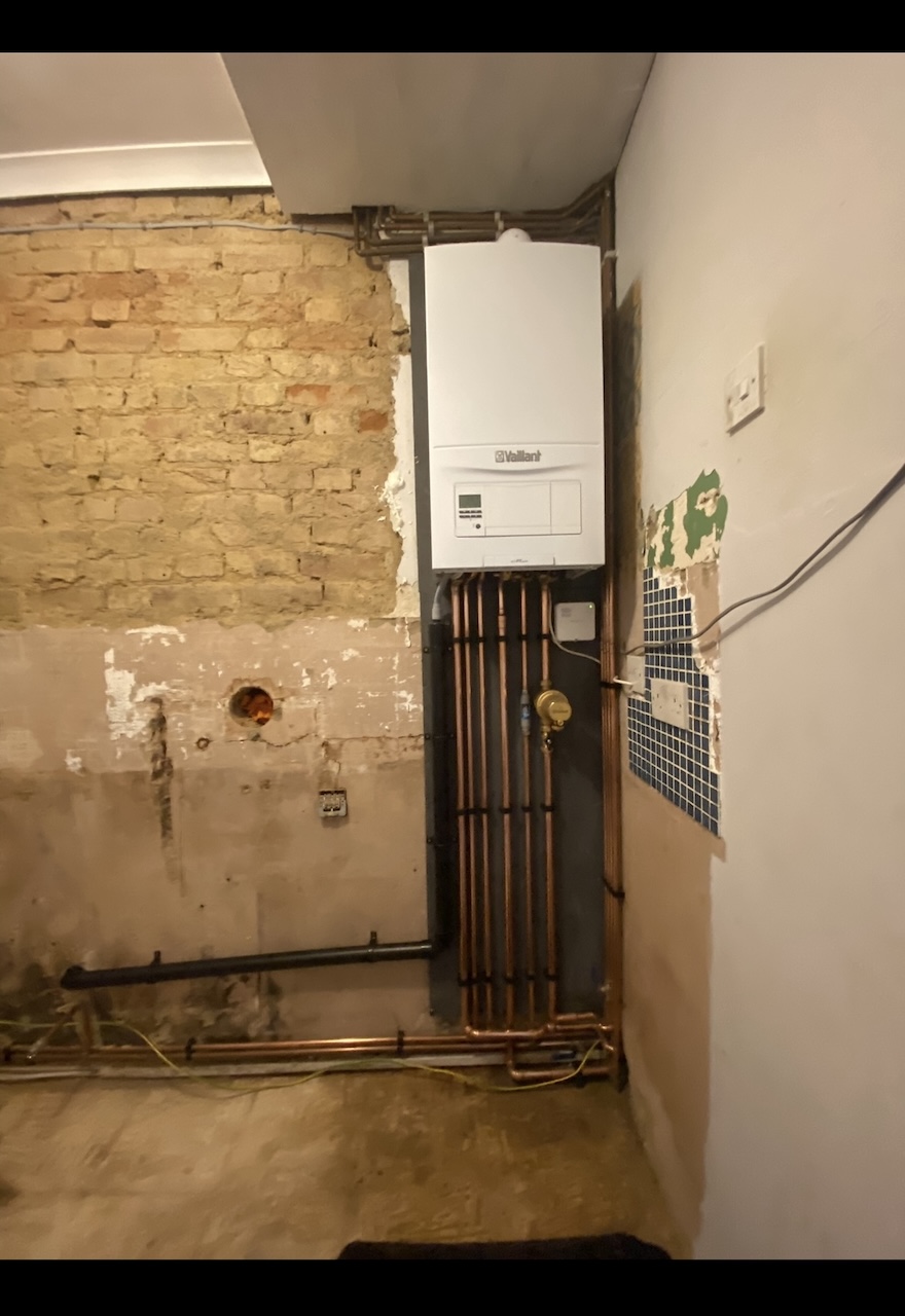 Bare brick room with wall plate and flue hole ready for boiler