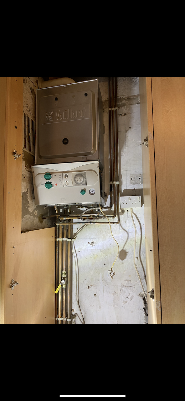 Old Vaillant boiler in cupboard before replacement