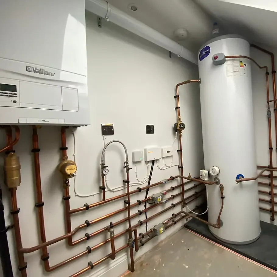 Wider view of plant room with Vaillant boiler, unvented cylinder and copper manifold runs